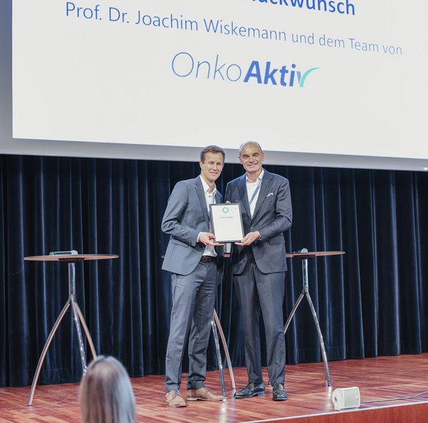 Joachim Wiskemann (links) erhält die Auszeichnung von Uwe Martens, dem Vorsitzenden des Krebsverbands Baden-Württemberg. 