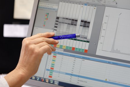 Mitarbeiterin zeigt Forschungsergebnisse auf dem Monitor